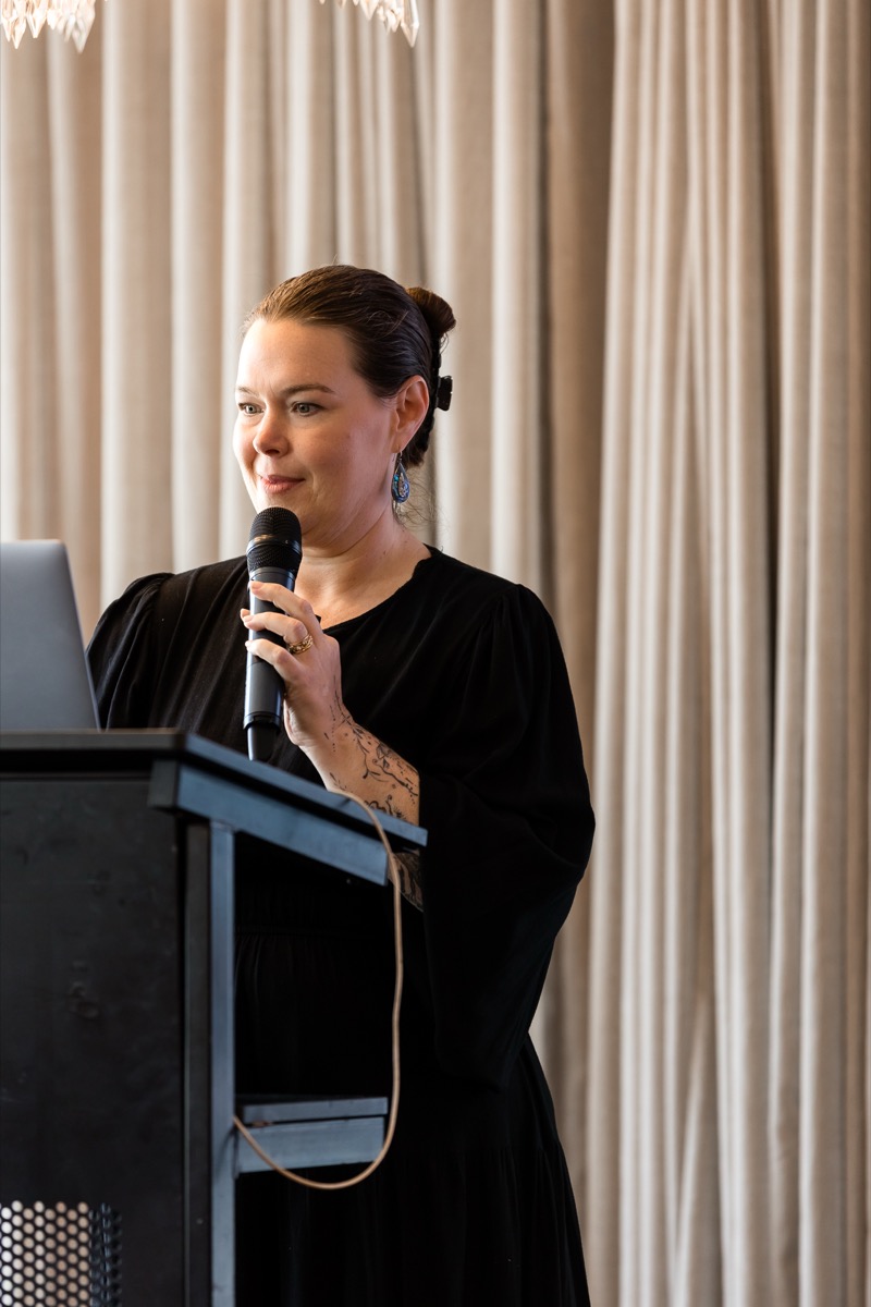 Kelly speaking on stage